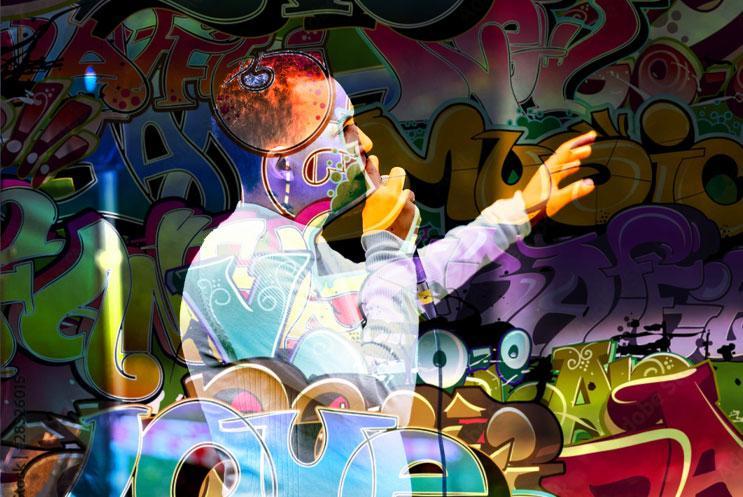 A person talking into a microphone, surrounded by street graffiti.