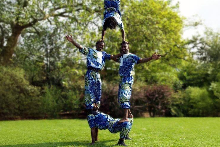 A group of acrobats balancing on each other to create a tower