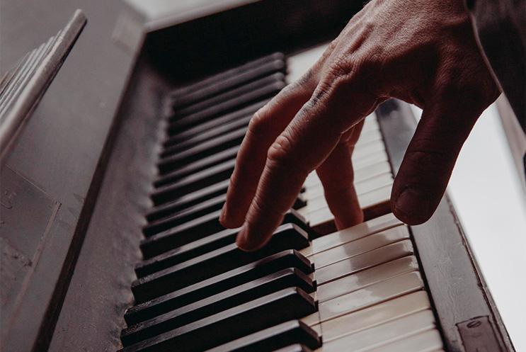 A hand playing a piano