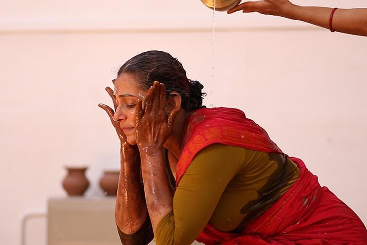 Woman putting clay on her face