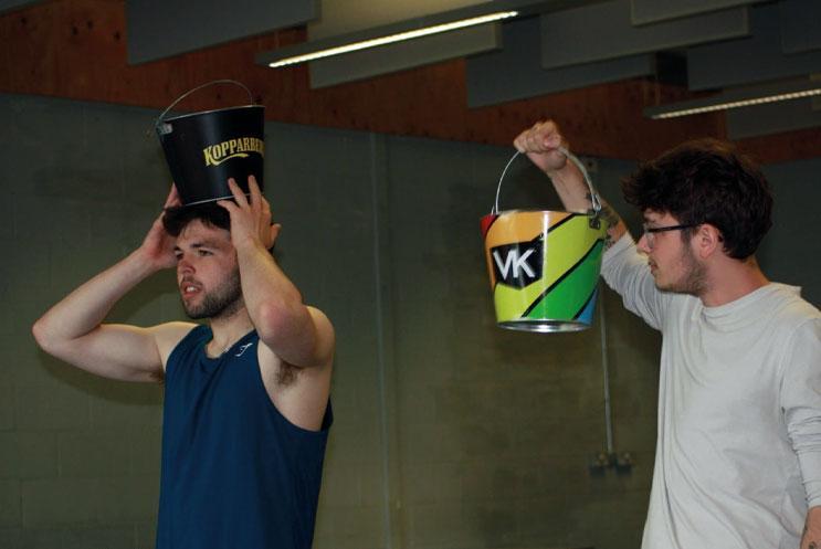 Two young people holding buckets