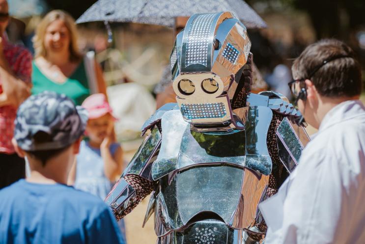 Young boy and scientist talking to a robot.