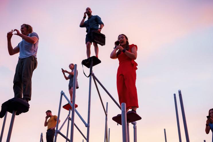 A group of performers standing on tall poles